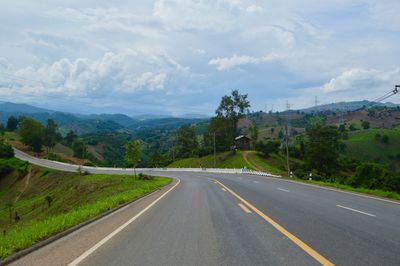 Road leading towards mountains against sky