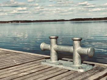 Close-up of pier on lake against sky