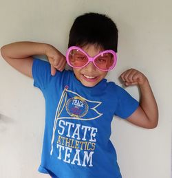 Portrait of smiling boy standing against blue wall