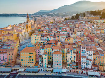 High angle view of townscape by sea against sky