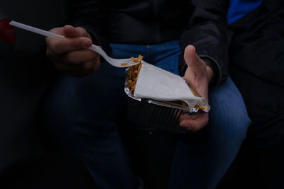 Midsection of man holding food in container and fork