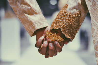 Cropped image of couple holding hands