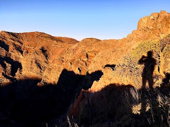 Panoramic view of people on rock against sky