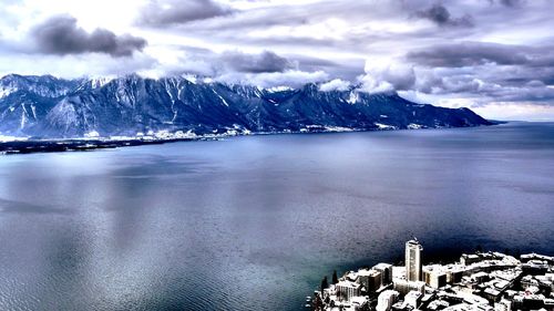 Scenic view of sea and snowcapped mountains against sky