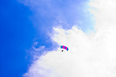 Low angle view of person paragliding against sky