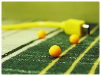 Close-up of yellow balls and cable on green carpet