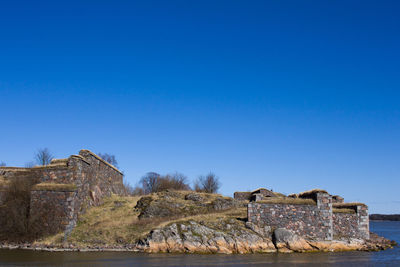 Old ruin on mountain against clear blue sky