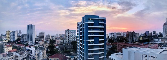 Buildings in city against sky during sunset