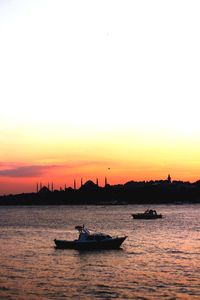 Silhouette boats in sea against clear sky during sunset