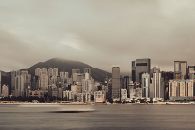 Buildings in city against cloudy sky