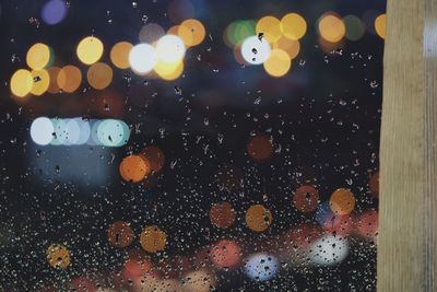 Illuminated lights seen through glass window at night