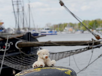 Close-up of sailboats moored at harbor against sky