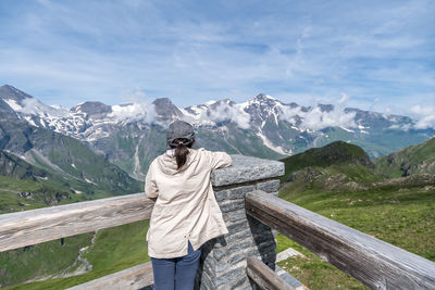 Rear view of woman standing on observation point looking at mountains during winter