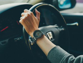 Close-up of hand holding camera in car