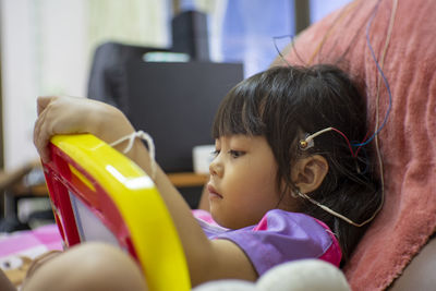 Cute girl with electrodes on head relaxing on chair