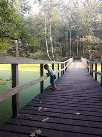 Rear view of boy on footbridge