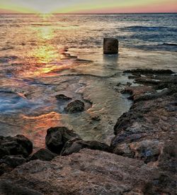 Close-up of rocks on beach against sky during sunset