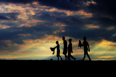 Silhouette people against sky during sunset