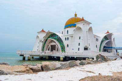 Mosque on sea against sky