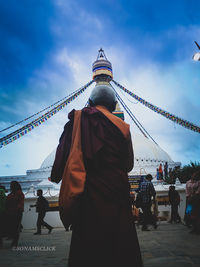 Group of people outside temple against sky