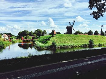 Traditional windmill on field against sky