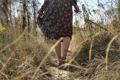 Low section of woman standing on field