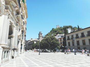 Buildings in city against clear blue sky