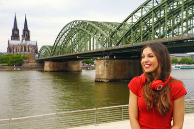 Woman against bridge over river in city