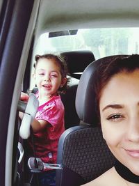 Portrait of smiling young woman sitting in car