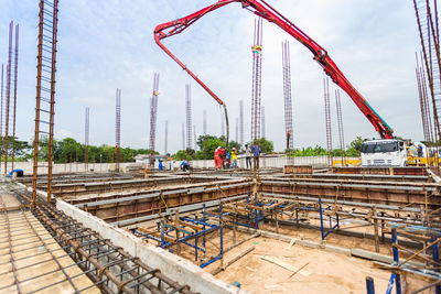 Cranes at construction site against sky