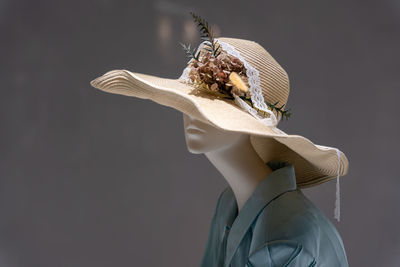 Portrait of woman wearing hat against black background