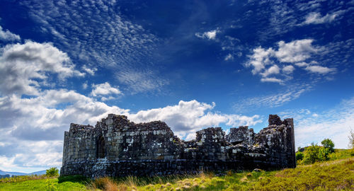 Low angle view of historical building against cloudy sky