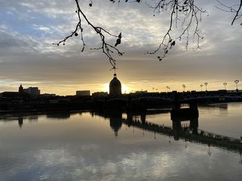 Reflection of building on river during sunset