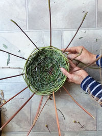 High angle view of hands making basket with nature