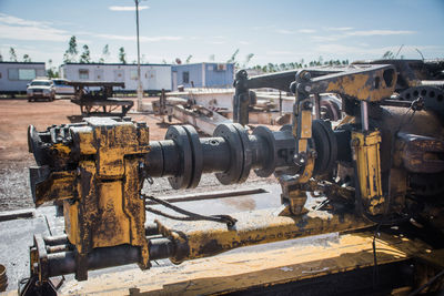 Close-up of rusty machine part against sky