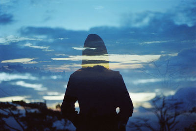 Double exposure of person standing against sky during sunset