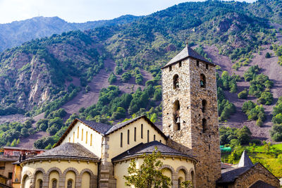 Low angle view of old building against mountain during sunny day