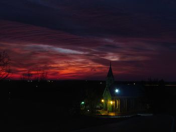 Illuminated city against sky at night