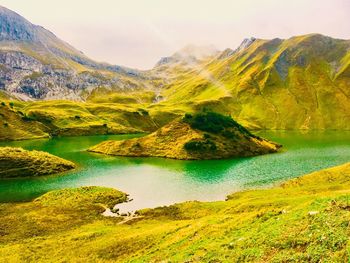 Scenic view of lake and mountains against sky