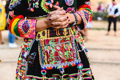 Midsection of woman standing against multi colored wall