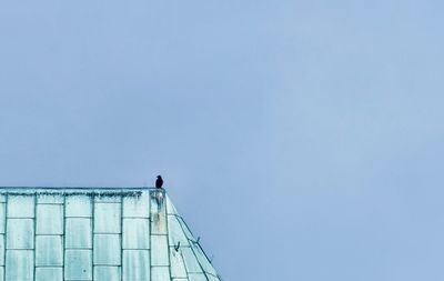 Low angle view of person standing against clear blue sky