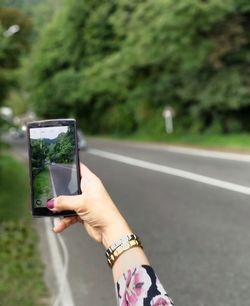 Midsection of man photographing with mobile phone