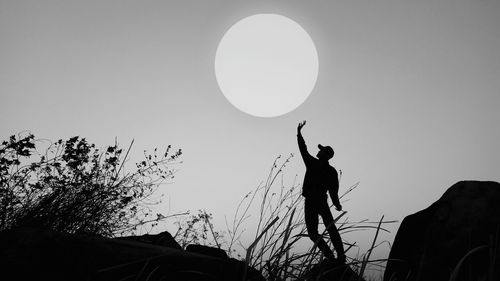 Low angle view of silhouette man standing against clear sky