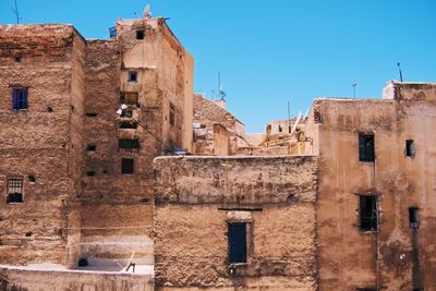 Low angle view of old building against clear blue sky