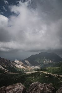 Scenic view of mountains against cloudy sky