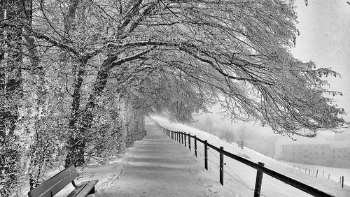 Snow covered footbridge against sky