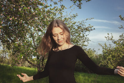 Smiling woman spinning around in garden scenic photography