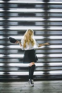 Rear view of woman standing in tunnel