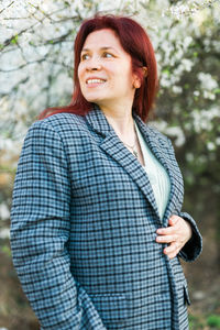 Young woman standing against trees