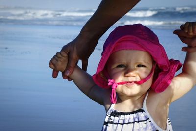 Cropped image of mother holding toddler at beach